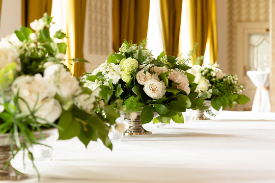 Floral centrepieces on long wedding table at The Balmoral Hotel Edinburgh with white roses and greenery