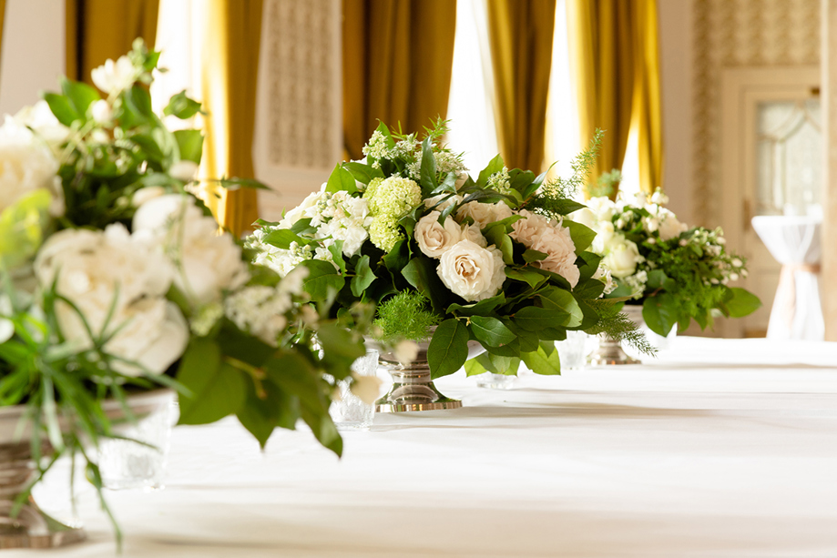 Floral centrepieces on long wedding table at The Balmoral Hotel Edinburgh with white roses and greenery