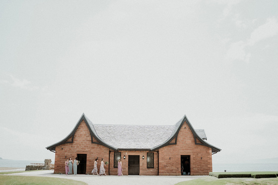 View of the boathouse with bridesmaids walking outside