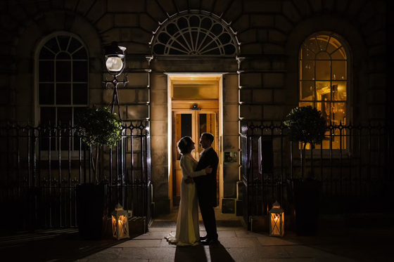Bride and groom embrace outside The Signet Library entrance