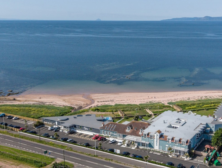 Drone view of The Waterside Hotel & Spa and its surrounding water.