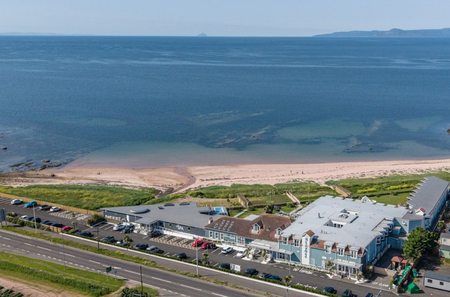 Drone view of The Waterside Hotel & Spa and its surrounding water.