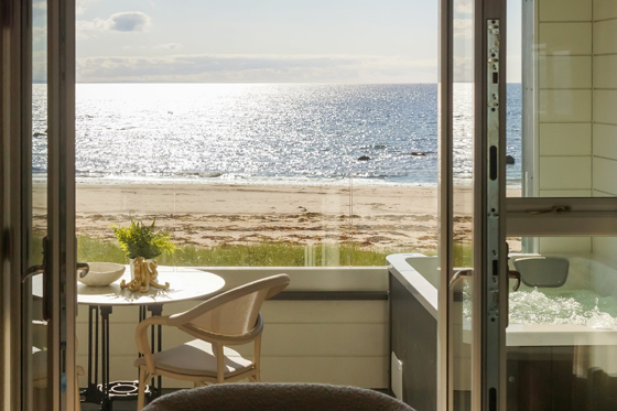 View of the beach and seaside with hottub on balcony at The Waterside Hotel