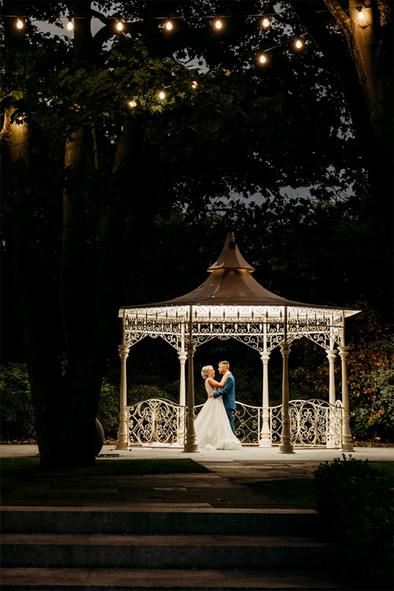 Night time image of a bride and groom dancing beneath the bandstand at Carlton Hotel