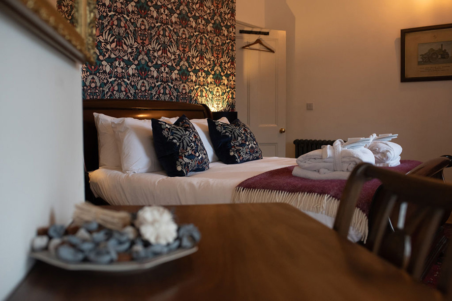 Castle Craigard bedroom with floral wallpaper, double bed and luxury robes