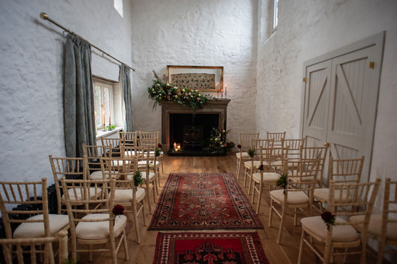 Intimate Castle Craigard wedding ceremony setup with fireplace and florals