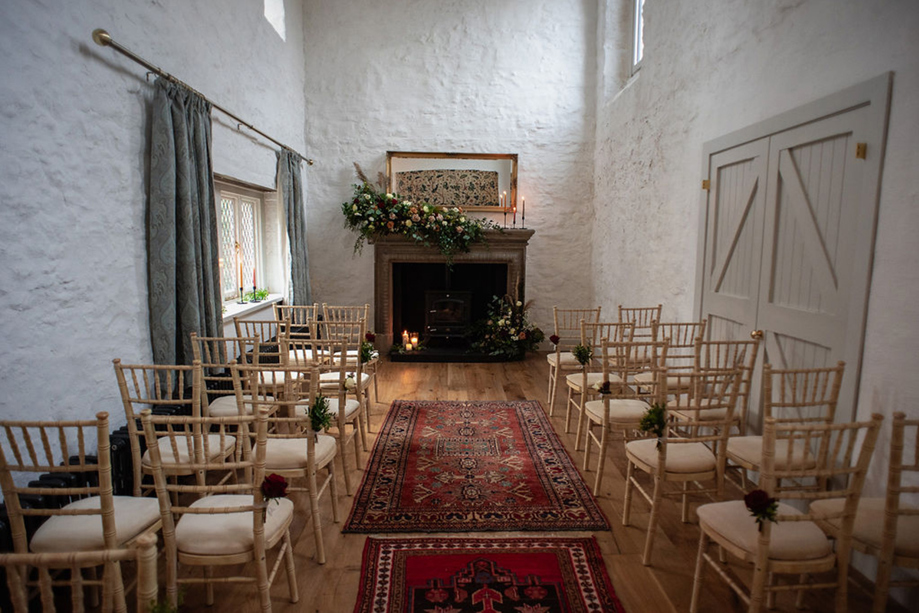 Intimate Castle Craigard wedding ceremony setup with fireplace and florals