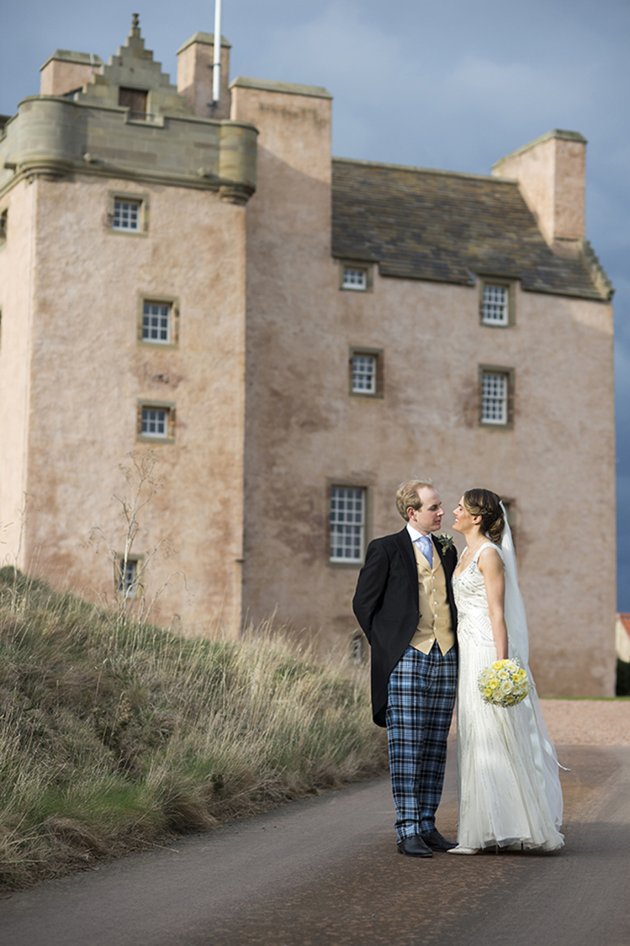 Bride and groom portrait outside Fenton Tower, with the historic Scottish wedding venue in the background