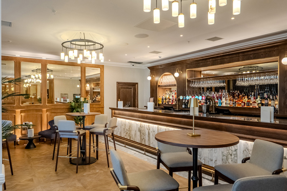 Bar area in The Exchange in Glasgow, with statement chandeliers and bar stools.