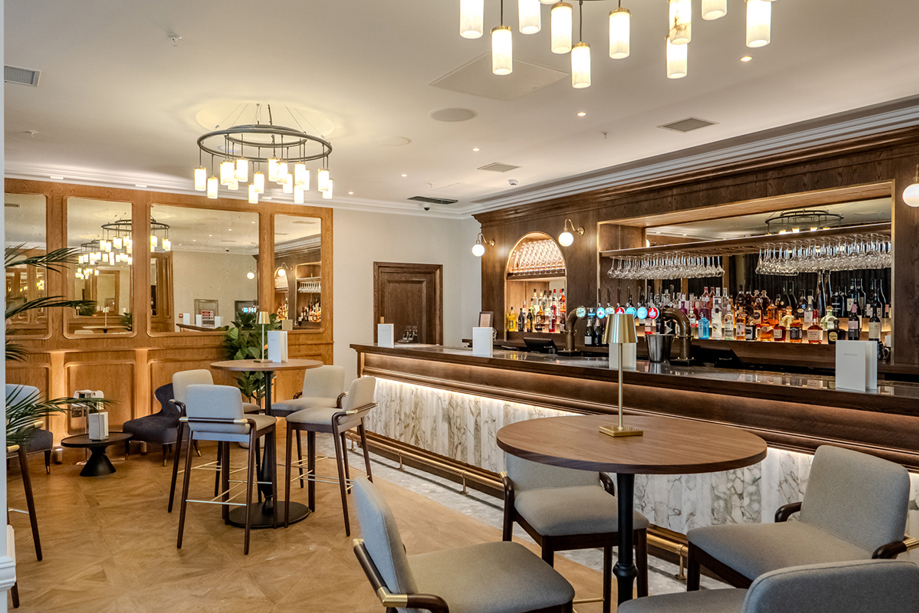 Bar area in The Exchange in Glasgow, with statement chandeliers and bar stools.