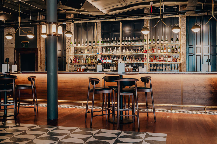 View of the bar in the Print Room at The Exchange in Glasgow, with barstools and checkered black and white dancefloor.