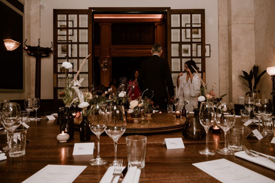 Bride and groom arriving for their wedding meal in a private dining room at Hawksmoor Edinburgh, with tables set and floral decor 