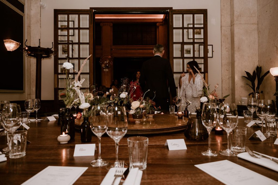 Bride and groom arriving for their wedding meal in a private dining room at Hawksmoor Edinburgh, with tables set and floral decor 