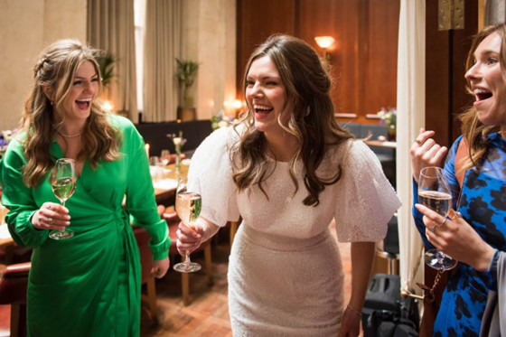 Bride and guests sharing a toast and laughing during a wedding reception at Hawksmoor Edinburgh.