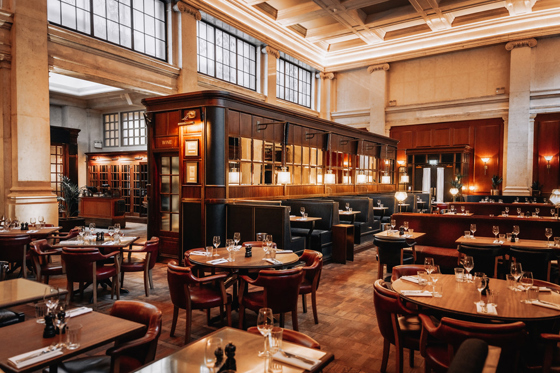 Hawksmoor Edinburgh’s grand dining room featuring high ceilings, large windows, leather seating and tables set for guests.
