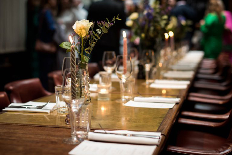 Elegant long table set for a wedding at Hawksmoor Edinburgh, featuring candles, glassware and minimalist floral decor.