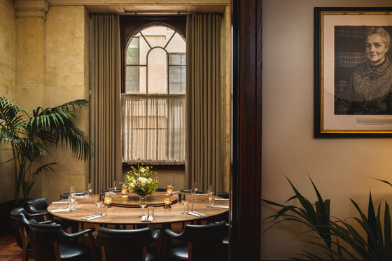 Hawksmoor Edinburgh private dining room featuring a round table, arched window, soft lighting and refined interior design.