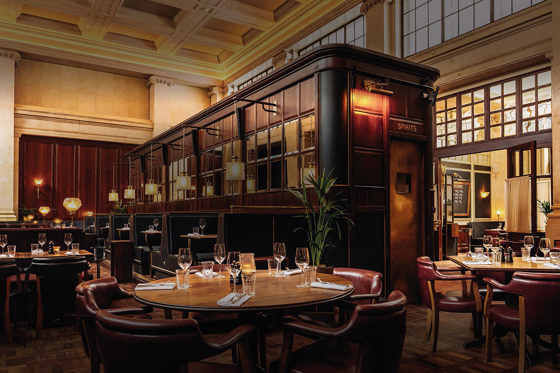 Image of the bar in food-focused venue Hawksmoor Edinburgh, with dark wood tones and warm lighting.