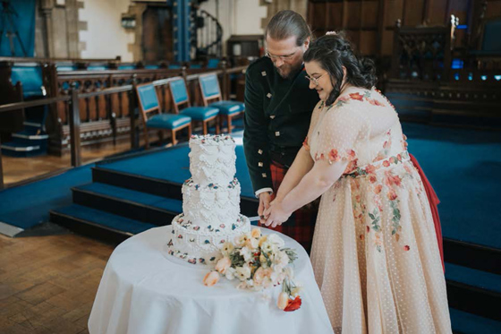 Bride and groom cut their three-tier cake at the University of Glasgow.