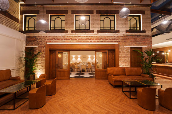 The Courtyard at The Collector's Hall with an all-weather glass canopy, herringbone flooring and tan leather couches