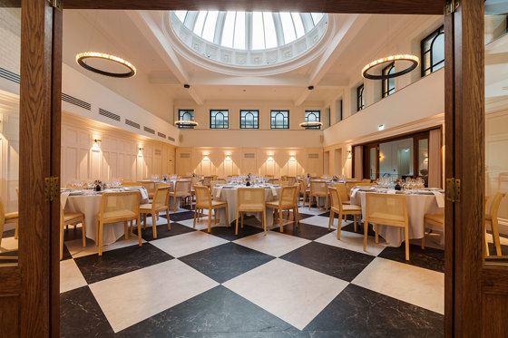 the collector's hall in glasgow set up for wedding dinner with black and white marble flooring and round tables in focus