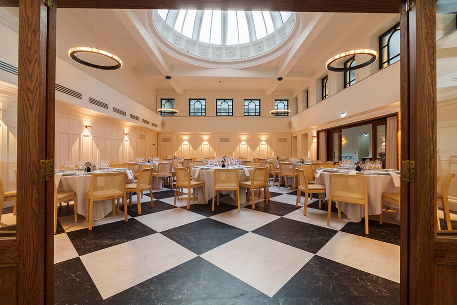 the collector's hall in glasgow set up for wedding dinner with black and white marble flooring and round tables in focus