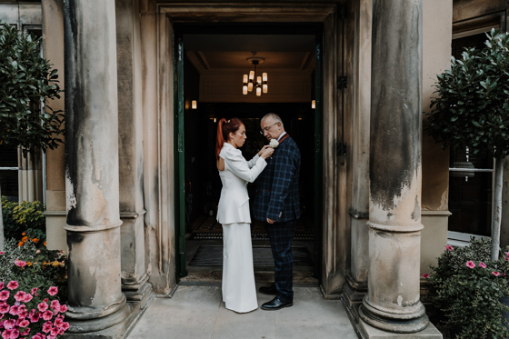 Bride fixes her father's buttonhole at the doors of The Scott Hotel in Edinburgh