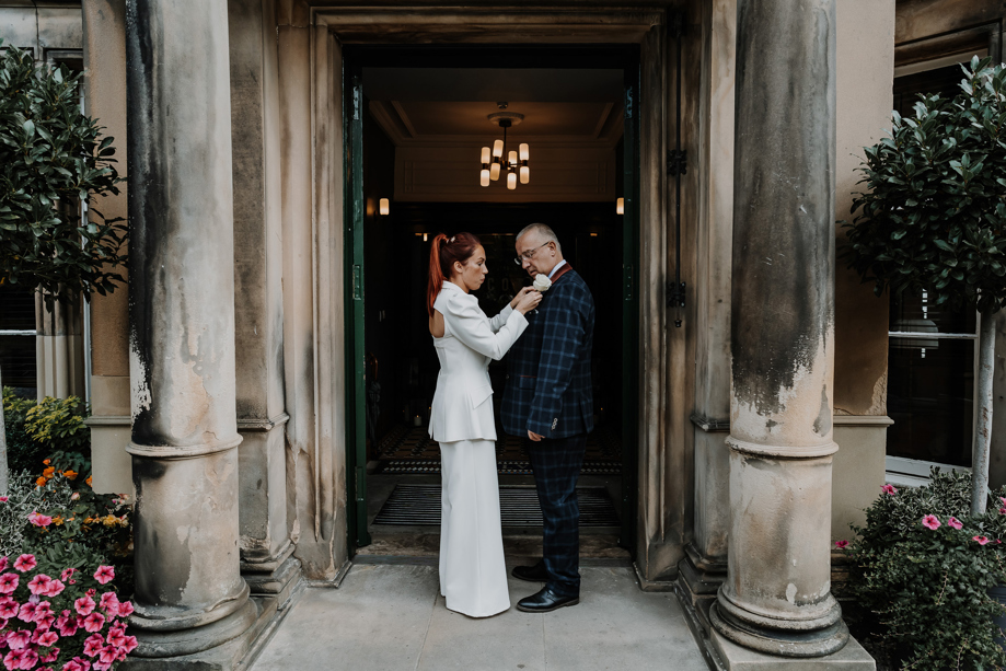 Bride fixes her father's buttonhole at the doors of The Scott Hotel in Edinburgh